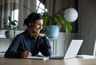 Happy,Young,Indian,Girl,With,Wireless,Headphones,Looking,At,Laptop